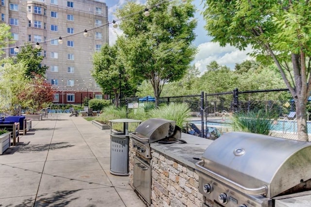 view of patio with grilling area, fence, and area for grilling