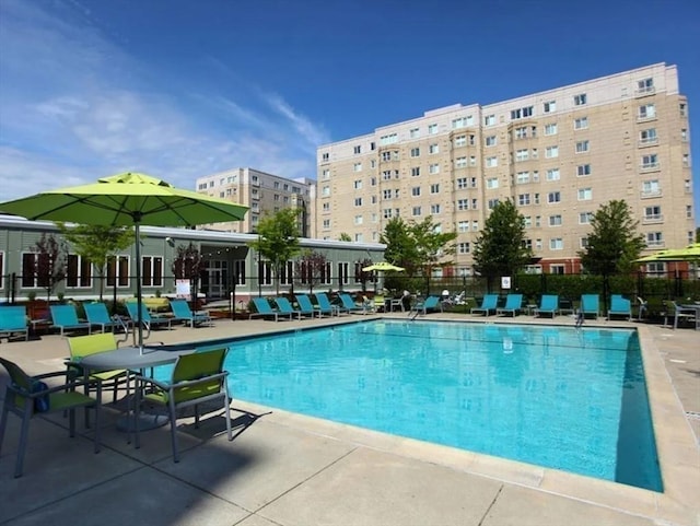 community pool featuring fence and a patio area
