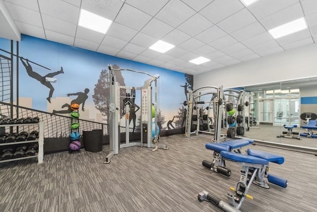 gym with carpet floors and a paneled ceiling