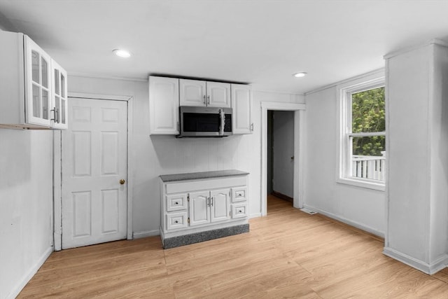 686-688 E Ave, Warwick, RI 02886 - kitchen with stainless steel microwave, white cabinetry, glass insert cabinets, light wood finished floors, and recessed lighting