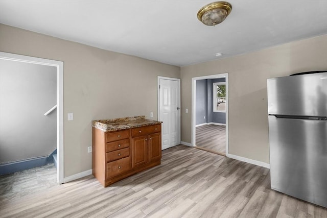 686-688 E Ave, Warwick, RI 02886 - kitchen featuring freestanding refrigerator, brown cabinetry, light wood-style flooring, and light stone countertops