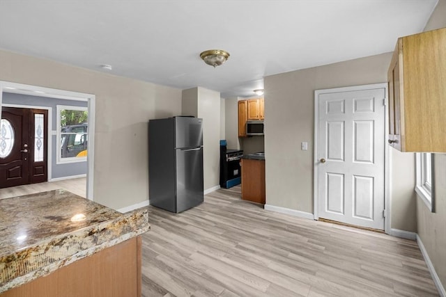 686-688 E Ave, Warwick, RI 02886 - kitchen with freestanding refrigerator, stainless steel microwave, light wood finished floors, and black range
