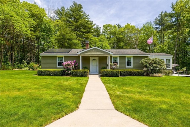9 Treadwell Ter, Spencer, MA 01562 - view of front facade featuring a front lawn, a chimney, and roof mounted solar panels