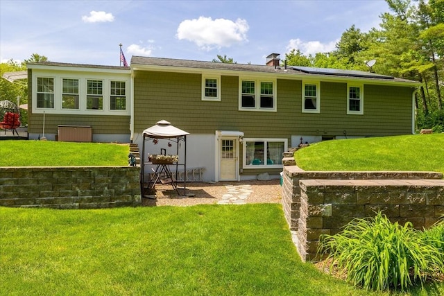 9 Treadwell Ter, Spencer, MA 01562 - rear view of house featuring a lawn, solar panels, a patio area, and a chimney