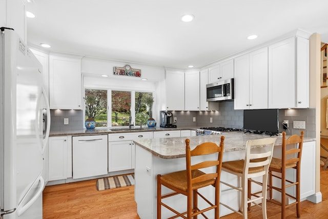 10 Lake Farm Ln, Orleans, MA 02653 - kitchen with white appliances, light wood-style flooring, a sink, decorative backsplash, and recessed lighting