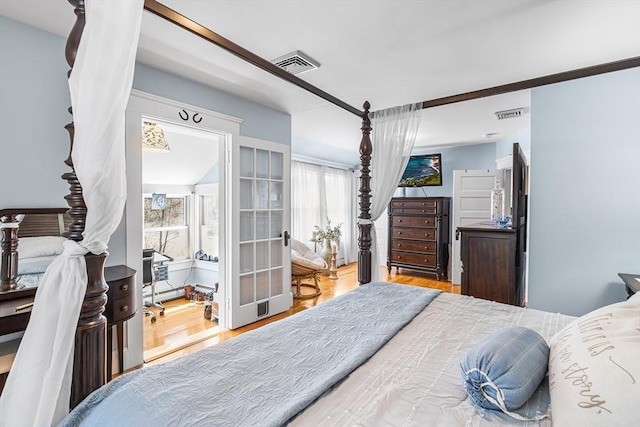bedroom featuring visible vents, a baseboard radiator, and wood finished floors