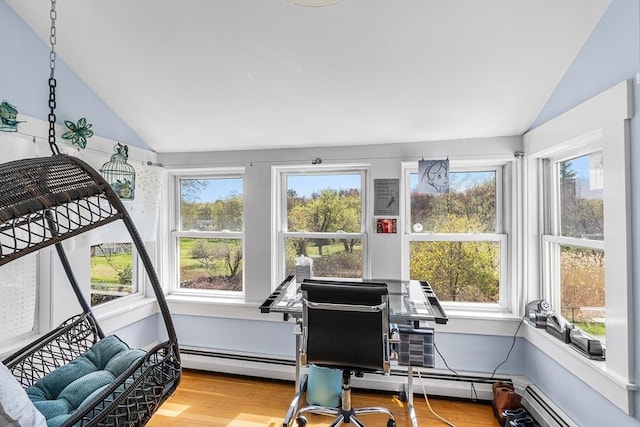 sunroom with vaulted ceiling, a baseboard heating unit, and wood finished floors