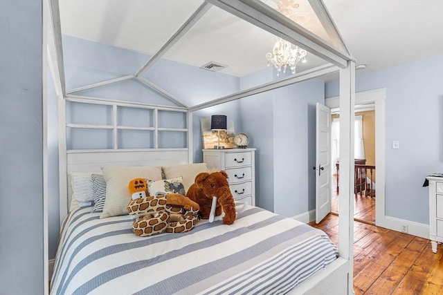 bedroom with visible vents, wood-type flooring, baseboards, and a chandelier