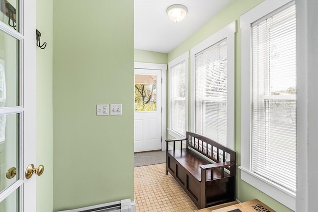 doorway to outside with a baseboard radiator and tile patterned floors
