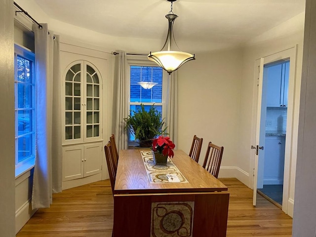 dining space featuring light wood-style floors and baseboards