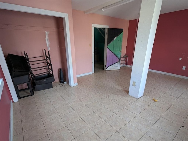 empty room featuring light tile patterned floors and baseboards