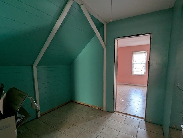 additional living space featuring lofted ceiling and tile patterned flooring