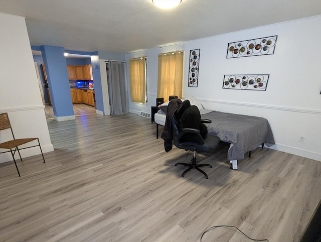 bedroom featuring visible vents, baseboards, and light wood-type flooring