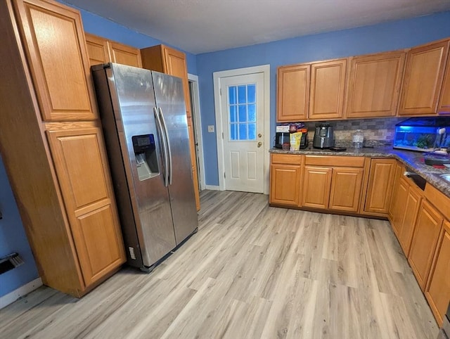 kitchen featuring tasteful backsplash, baseboards, stainless steel fridge with ice dispenser, light wood-type flooring, and brown cabinetry