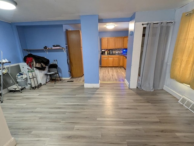 unfurnished dining area with light wood-style flooring, baseboards, and visible vents