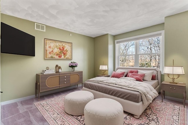 carpeted bedroom with visible vents and baseboards