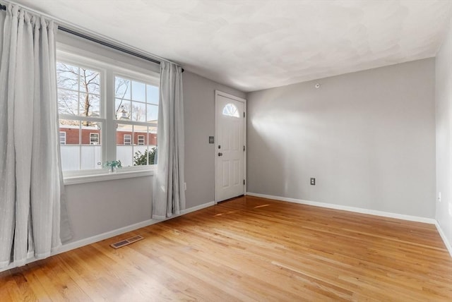 foyer featuring wood finished floors, visible vents, and baseboards