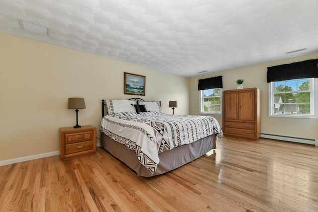 186 Mitchell G Dr, Tewksbury, MA 01876 - bedroom featuring a baseboard heating unit, light wood finished floors, and baseboards