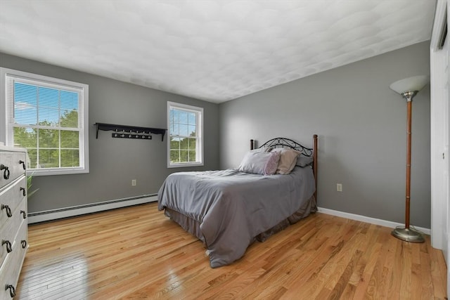 186 Mitchell G Dr, Tewksbury, MA 01876 - bedroom with baseboard heating, multiple windows, light wood-style flooring, and baseboards