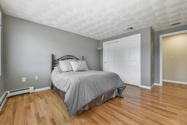 186 Mitchell G Dr, Tewksbury, MA 01876 - bedroom with a closet, baseboards, light wood-type flooring, and a baseboard heating unit