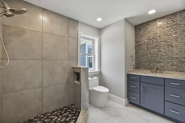 bathroom with vanity, toilet, and a tile shower