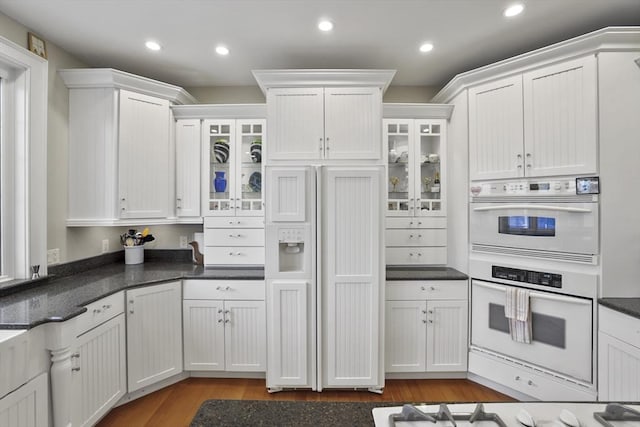 kitchen with paneled refrigerator, white cabinets, and double oven