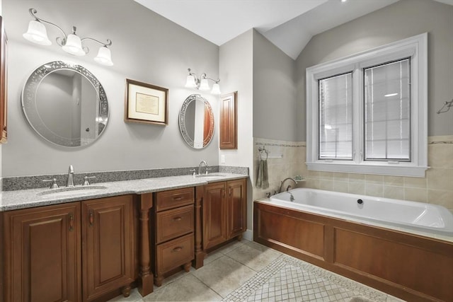 bathroom with tile patterned floors, a bath, vaulted ceiling, and vanity