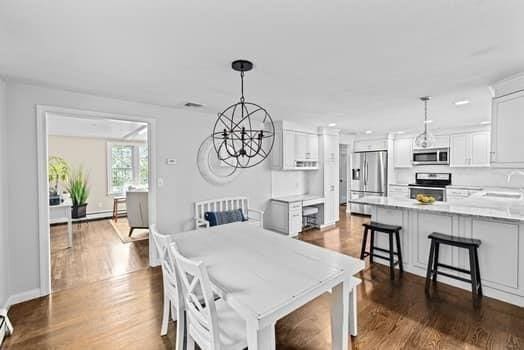 28 Christopher Ln, Scituate, MA 02066 - dining area featuring dark wood-style floors and a chandelier