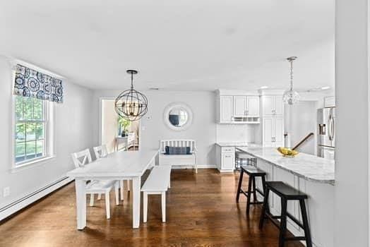 28 Christopher Ln, Scituate, MA 02066 - dining room featuring baseboard heating, a chandelier, and dark wood-style floors