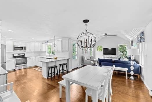 28 Christopher Ln, Scituate, MA 02066 - dining room featuring a chandelier, a ceiling fan, lofted ceiling, and wood finished floors