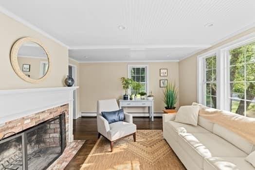 28 Christopher Ln, Scituate, MA 02066 - living room featuring a baseboard radiator, wood finished floors, a fireplace with raised hearth, and ornamental molding