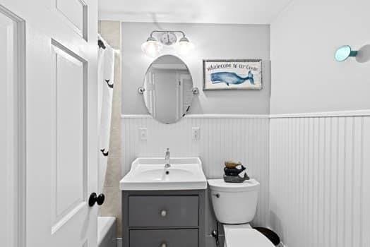 28 Christopher Ln, Scituate, MA 02066 - bathroom featuring vanity, wainscoting, and shower / bath combo