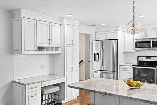 28 Christopher Ln, Scituate, MA 02066 - kitchen with stainless steel appliances, white cabinetry, light stone counters, decorative light fixtures, and recessed lighting