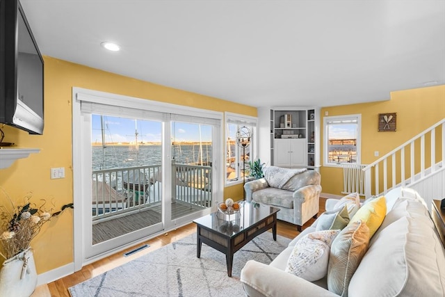 living room with a water view and light wood-type flooring