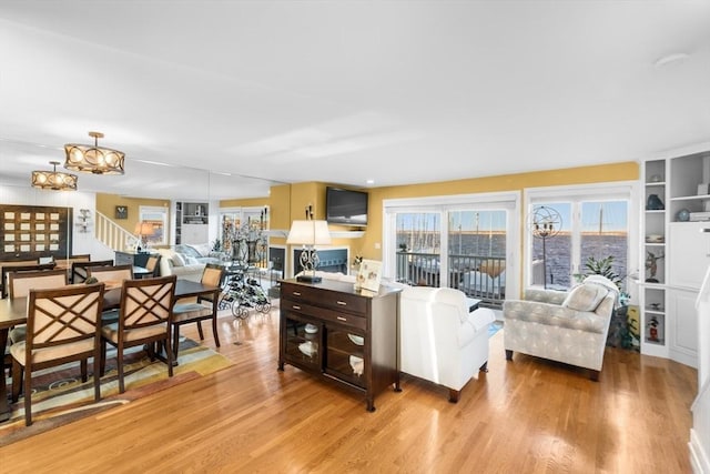 living room with light hardwood / wood-style flooring and a notable chandelier