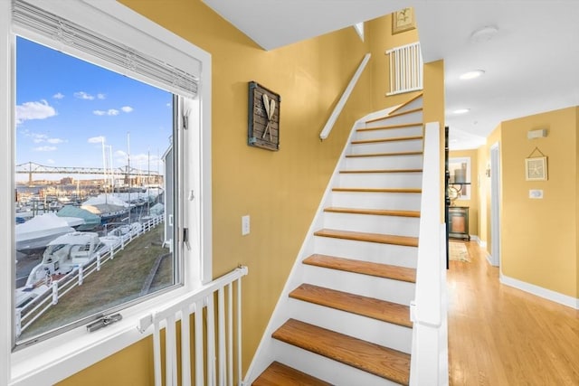 stairway with hardwood / wood-style flooring and a healthy amount of sunlight