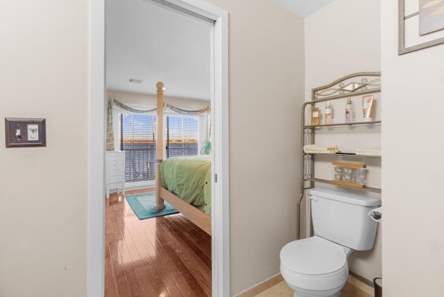 bathroom with hardwood / wood-style flooring and toilet