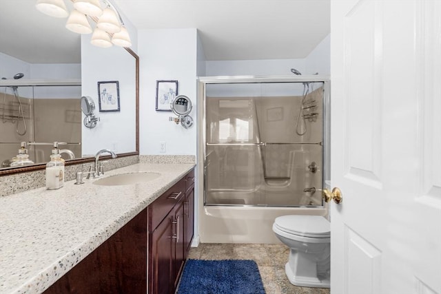 full bathroom featuring vanity, toilet, and bath / shower combo with glass door