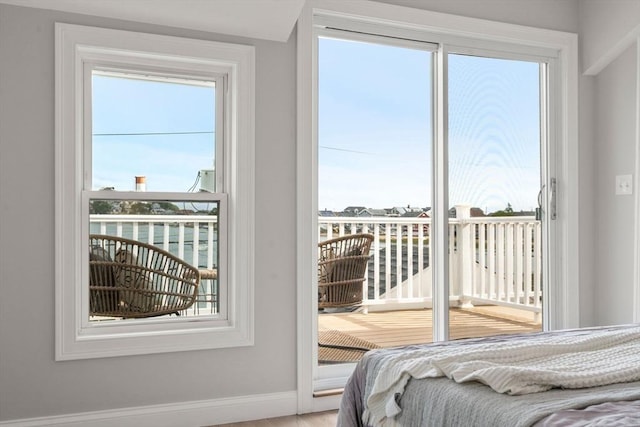 bedroom with baseboards and access to exterior