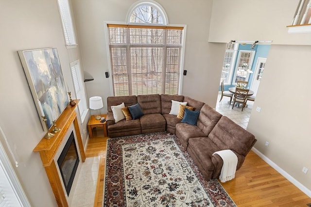 living room with light wood-style floors and a glass covered fireplace