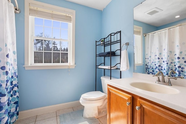 bathroom with toilet, baseboards, plenty of natural light, and tile patterned flooring