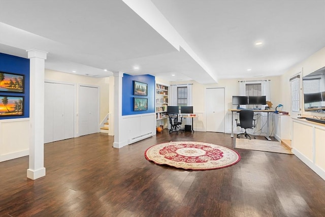 interior space featuring decorative columns, built in shelves, wood finished floors, stairway, and a baseboard radiator
