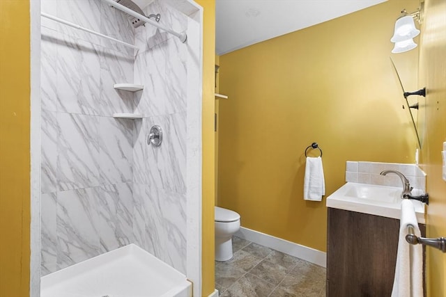 full bathroom with vanity, baseboards, a stall shower, and toilet