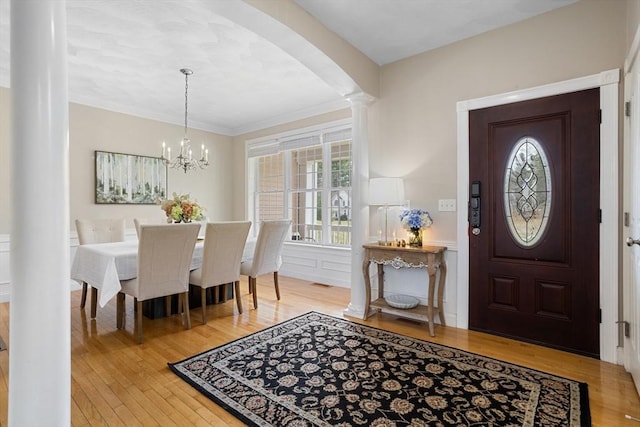 entryway featuring crown molding, arched walkways, and hardwood / wood-style flooring
