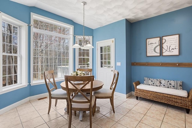 dining space featuring plenty of natural light, baseboards, and light tile patterned flooring