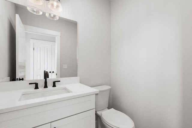 bathroom featuring an inviting chandelier, vanity, and toilet