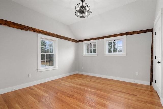 empty room with ceiling fan, light wood-type flooring, and lofted ceiling