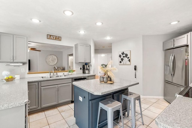 10 Gianna Dr, Saugus, MA 01906 - kitchen featuring stainless steel appliances, light tile patterned floors, a kitchen island, a breakfast bar area, and gray cabinets