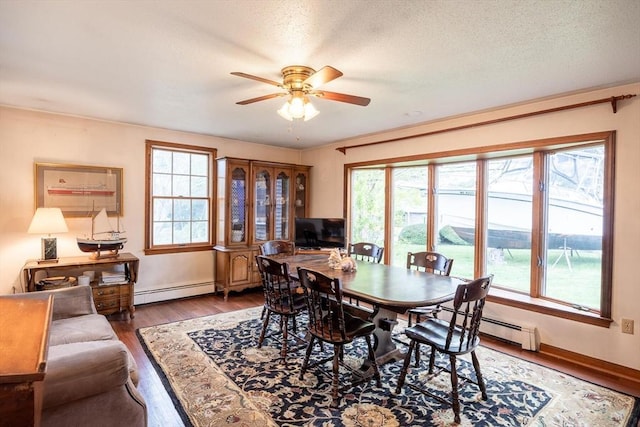 dining area with baseboard heating, ceiling fan, wood finished floors, and baseboards