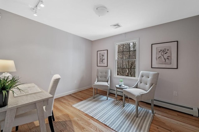 office space featuring visible vents, baseboards, wood finished floors, and rail lighting